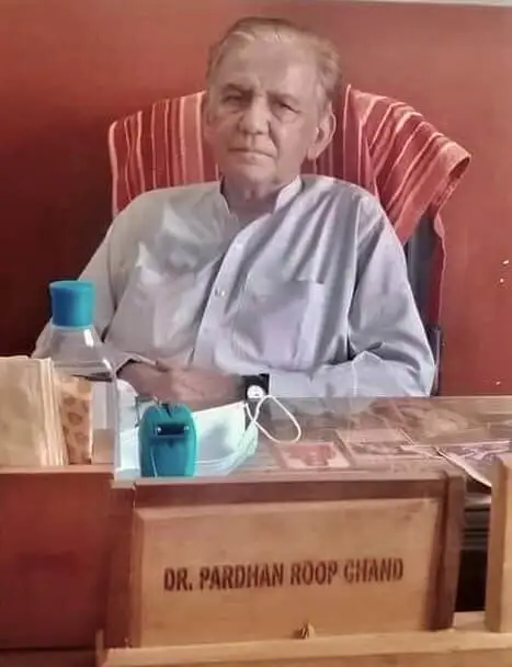 Dr. Pardhan Roopani sitting on chair in his Roop Clinic for serving patients