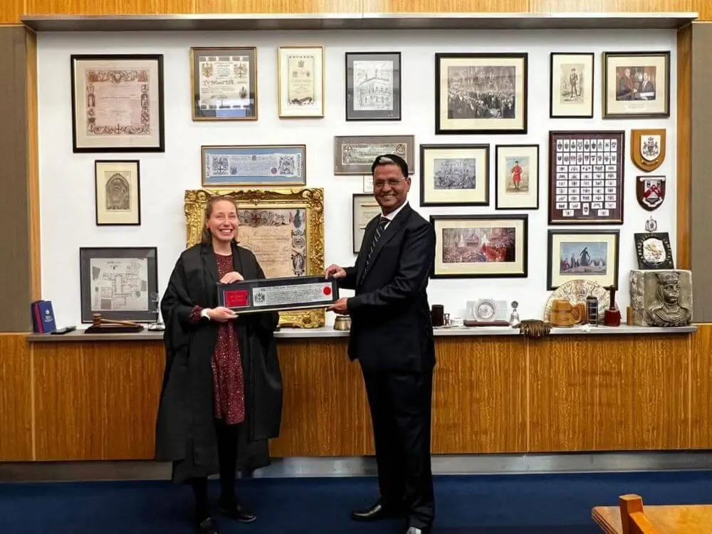 Prof. Dr. Bekha Ram Devrajani in black blaze with tie dress, standing and receiving 'Freedom of City of London', the Highest Award in London. Award received in the court of Chamberlain London, in March 2024